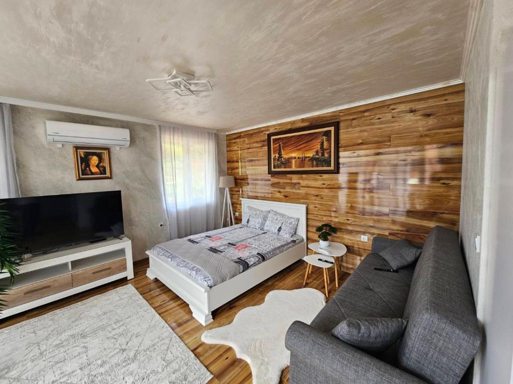 a living room with a bed and a couch at Апартамент за гости Боляри in Velingrad