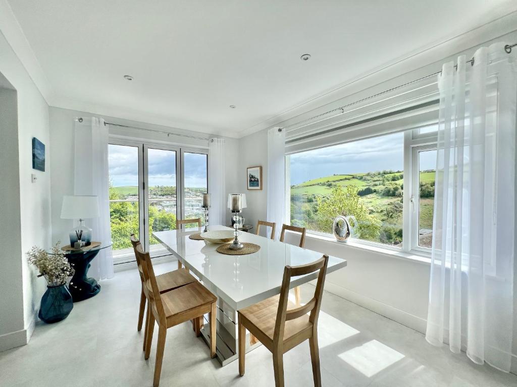 a dining room with a table and chairs and a large window at Incredible Views in Dartmouth with Parking and EV Charger in Dartmouth