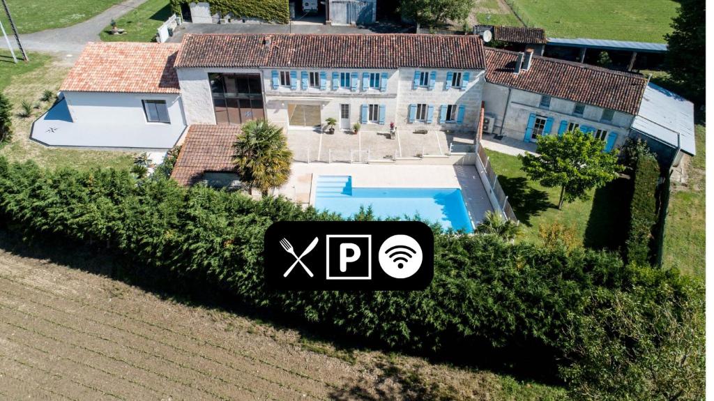 - une vue aérienne sur une grande maison avec une piscine dans l'établissement Les Cuves - Saintes, à Chaniers