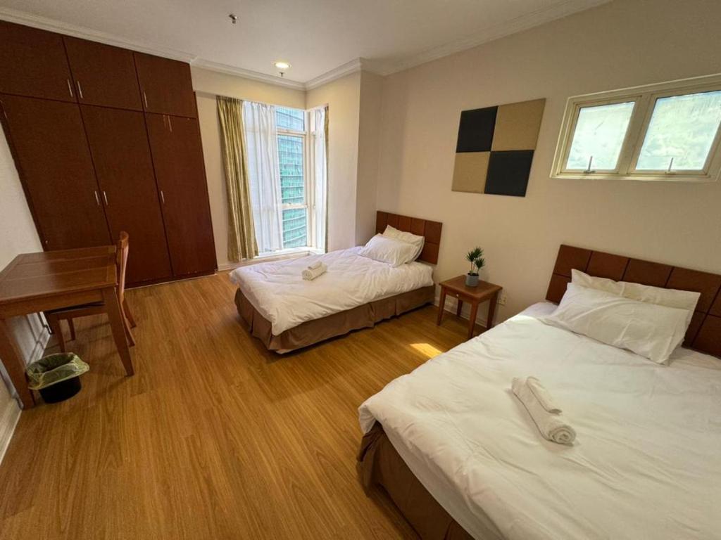 a hotel room with two beds and a desk at StayInn Gateway Hotel Apartment, 2-bedroom Kuching City PrivateHome in Kuching