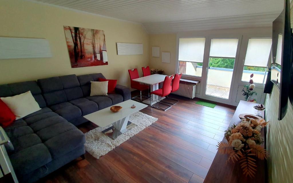 ein Wohnzimmer mit einem blauen Sofa und einem Tisch in der Unterkunft Appartementwohnung Central Bad Sachsa in Bad Sachsa