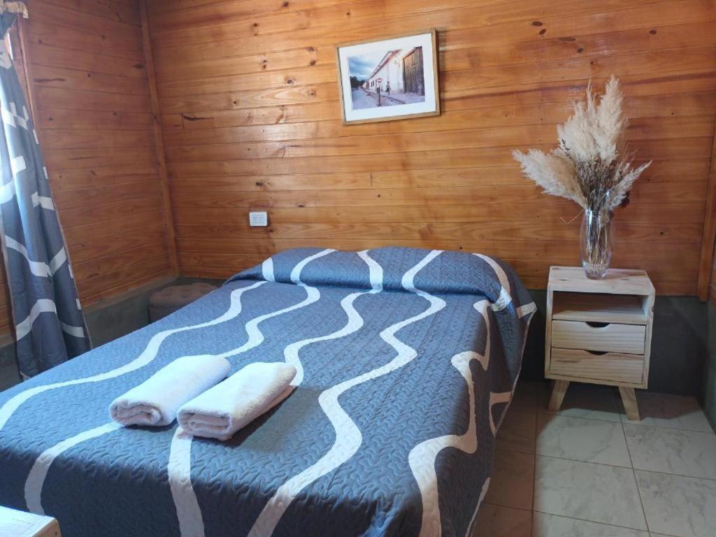 a bedroom with a bed with two towels on it at Cabaña Cachi in Cachí