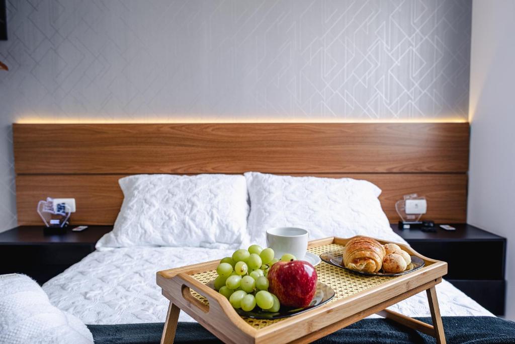 a tray of fruit and croissants on a bed at Apartamento Autódromo de Interlagos sp in Sao Paulo