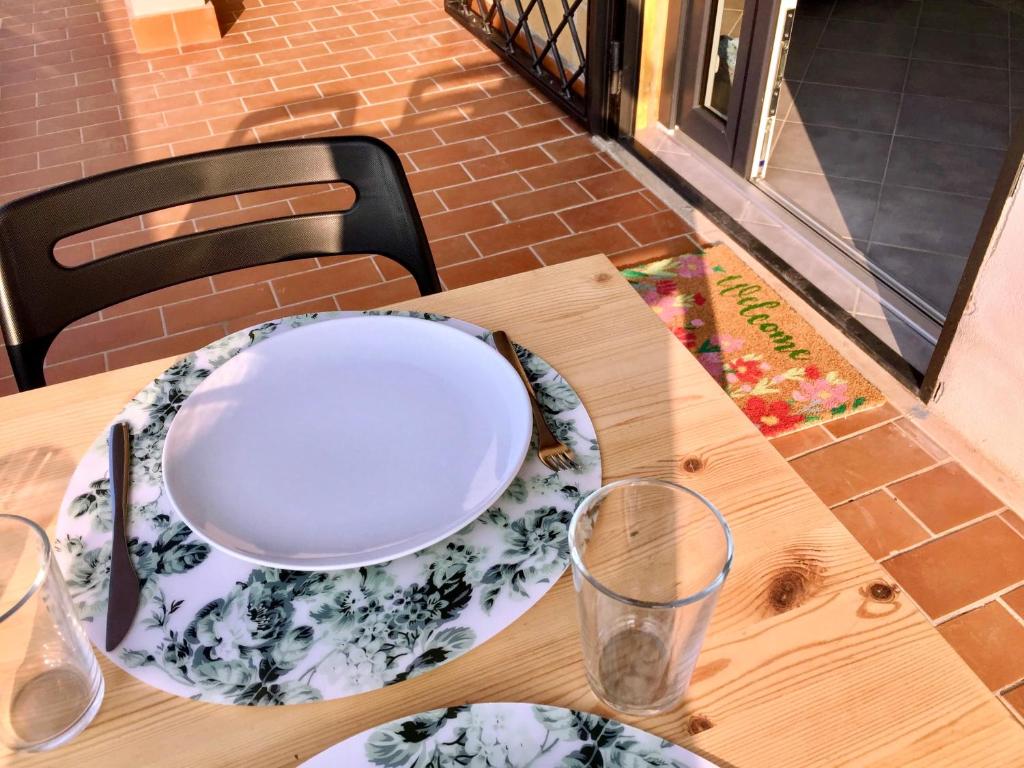 una mesa de madera con un plato y gafas. en Casa Zefiro, tra mare e pineta! en Fregene