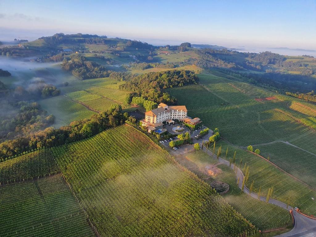 an aerial view of a mansion in the middle of a field at Spa do Vinho Condomínio Vitivinícola in Bento Gonçalves