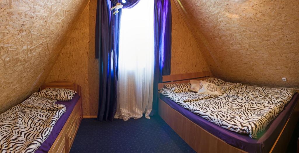 two beds in a small room with a window at Grāveri kempings in Usma