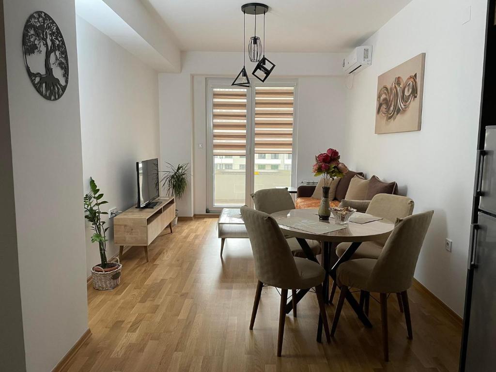 a dining room and living room with a table and chairs at Golden Apartments Skopje in Skopje