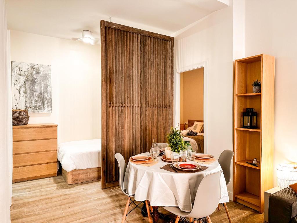 a dining room with a table and a bedroom at apartamento muy próximo a Valencia in Burjassot