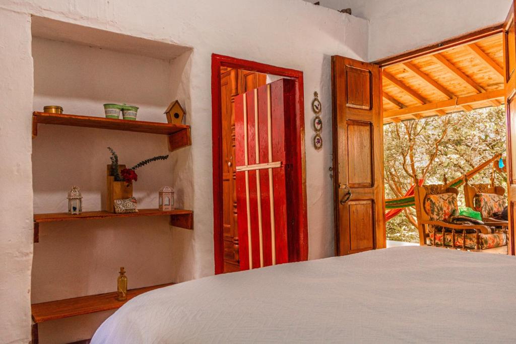 sypialnia z łóżkiem i otwartymi drzwiami w obiekcie Cabaña Rustica w mieście Montebello