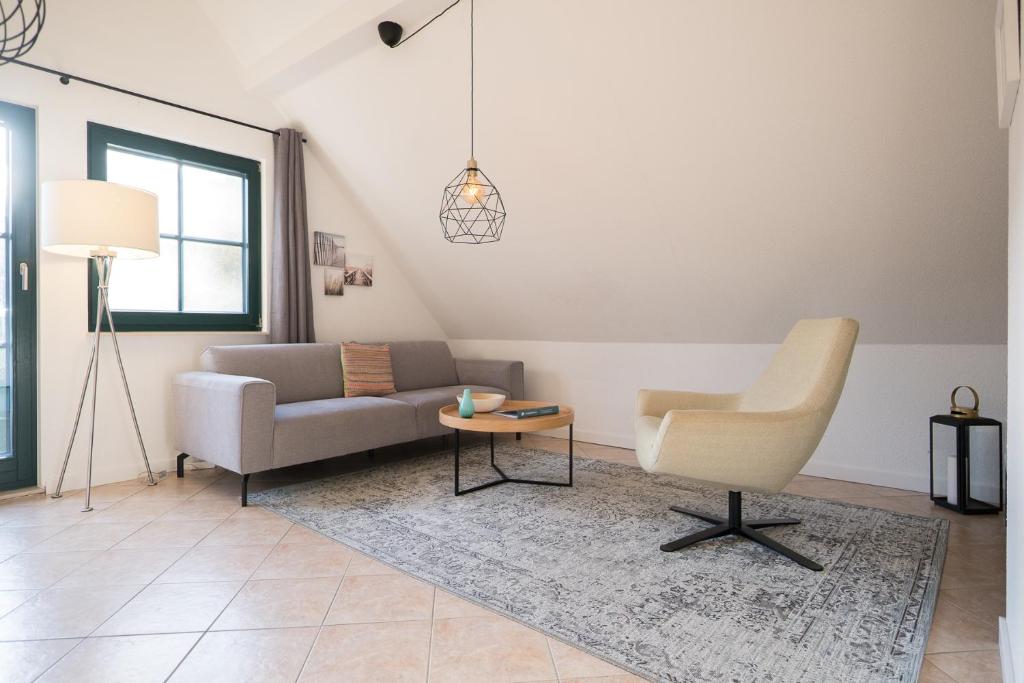 a living room with a couch and a chair at Ferienwohnung Lee West 2 3 in Dierhagen