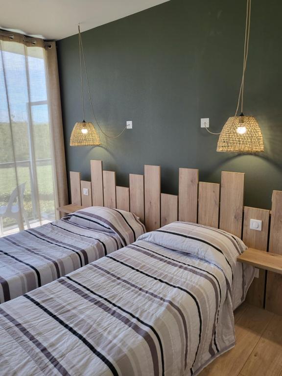 two beds sitting next to each other in a bedroom at Logis Le Cadusia in Chaource