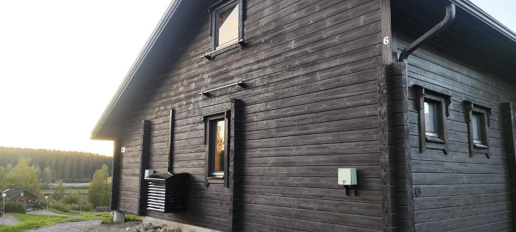ein schwarzes Gebäude mit Seitenfenstern in der Unterkunft Himos, Areenan alue in Jämsä