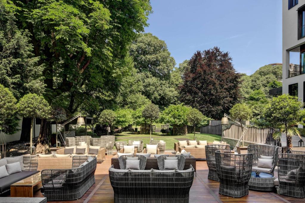 a patio with couches and chairs in a yard at Bulgari Hotel Milano in Milan