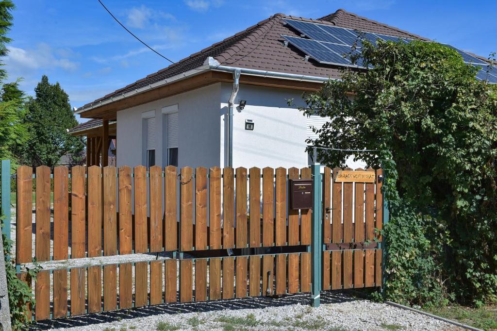 una valla de madera frente a una casa en Borács Winedégház en Bogács