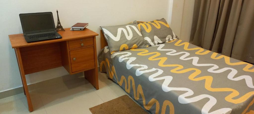 1 dormitorio con 1 cama y escritorio con ordenador portátil en SOFT LINK APARTMENT, en Moratuwa