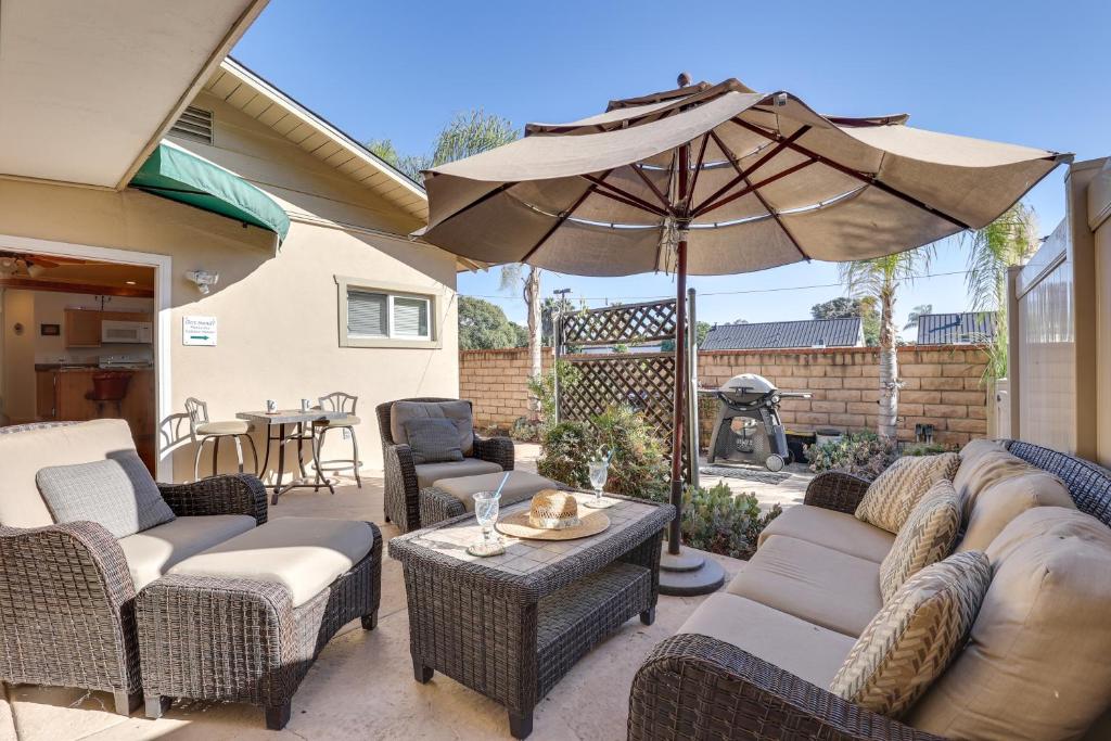 a patio with chairs and an umbrella and a table at Downtown Carlsbad Apartment Less Than half Mi to Beach! in Carlsbad