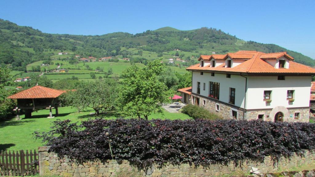 une maison avec un toit orange sur une colline dans l'établissement Hotel Rural Casa de la Veiga, à San Esteban
