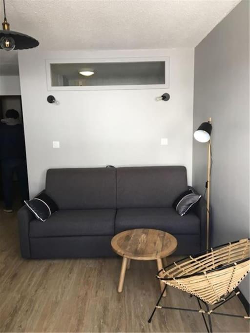 uma sala de estar com um sofá preto e uma mesa em Appartement Vue Montagne em Val Louron