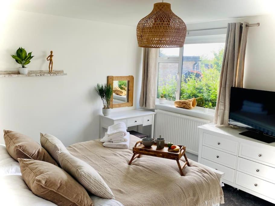 een woonkamer met een bank en een televisie bij Tranquil Bridge Escape in Canterbury