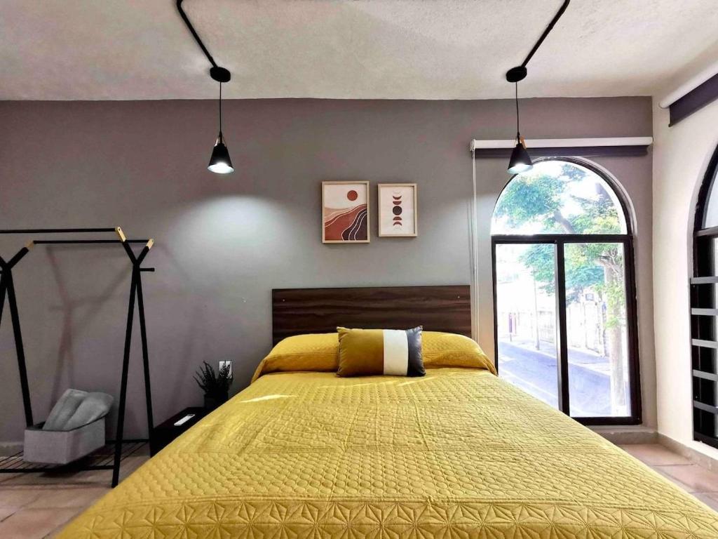 a bedroom with a yellow bed and a window at Estudio 2 personas en el Centro/agencias aduanales in Veracruz