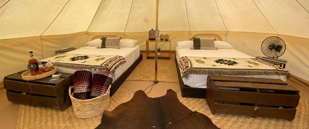 a room with two beds in a tent at Glamping San Isidro in Laguna de Sánchez