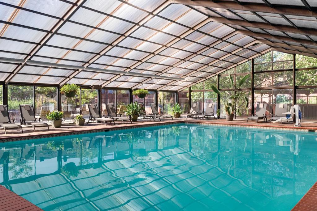 an indoor swimming pool with a glass ceiling at Radisson Hotel Colorado Springs Airport in Colorado Springs