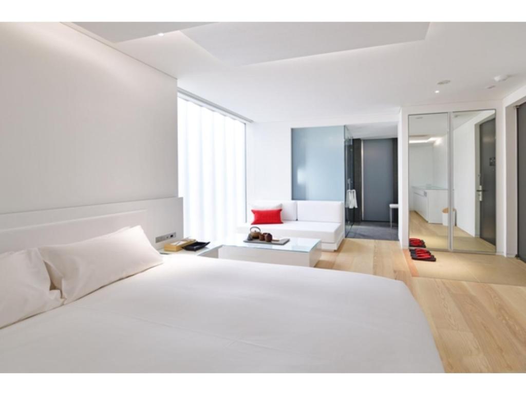 um quarto com uma cama branca e uma sala de estar em MOGANA - Vacation STAY 59258v em Quioto