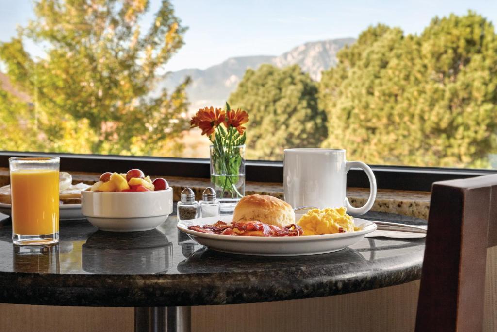 a breakfast table with a plate of breakfast food and a window at Radisson Hotel Colorado Springs Airport in Colorado Springs