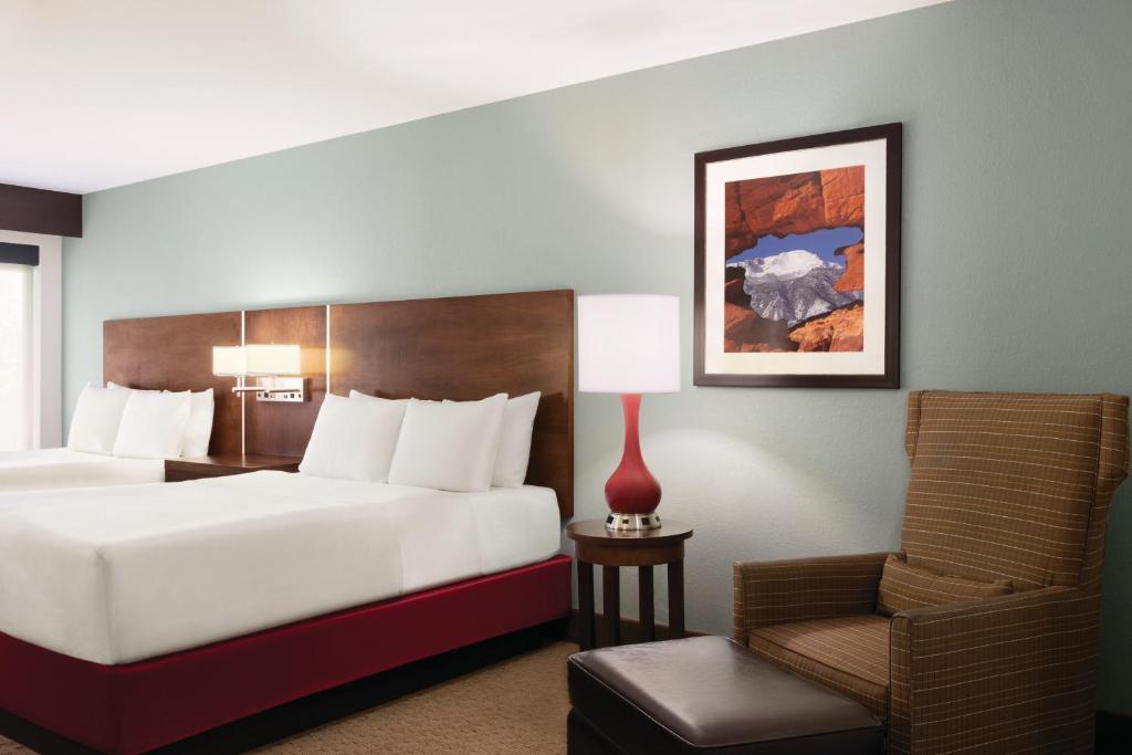 a hotel room with a bed and a chair at Radisson Hotel Colorado Springs Airport in Colorado Springs
