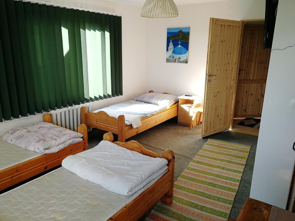 um quarto com três camas e uma janela em Na Dziole em Lipnica Wielka