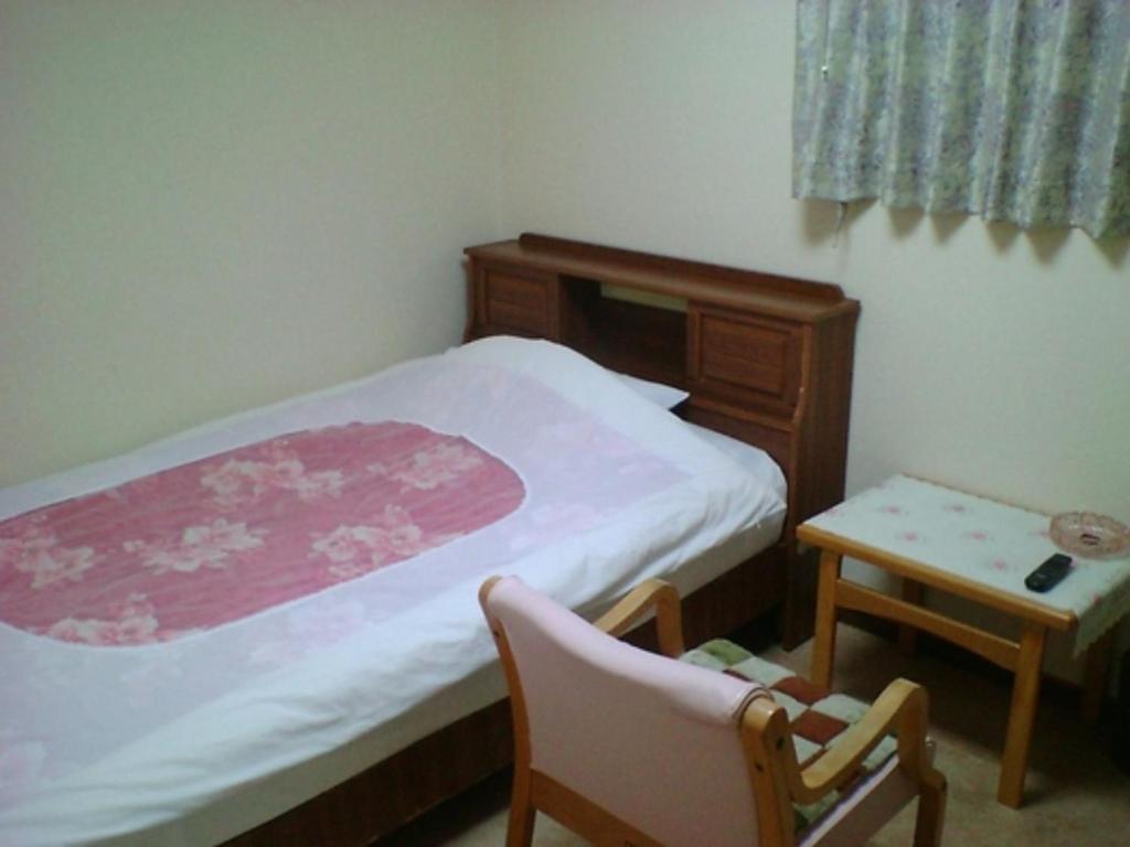 a bedroom with a bed and a chair and a table at Minshuku Suzu - Vacation STAY 21226v in Shimanto
