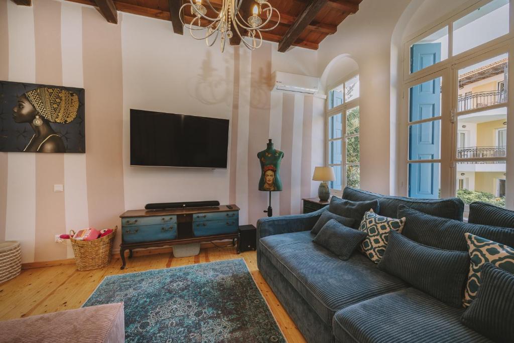 a living room with a couch and a flat screen tv at Minoos Residence with roof pool in Rethymno