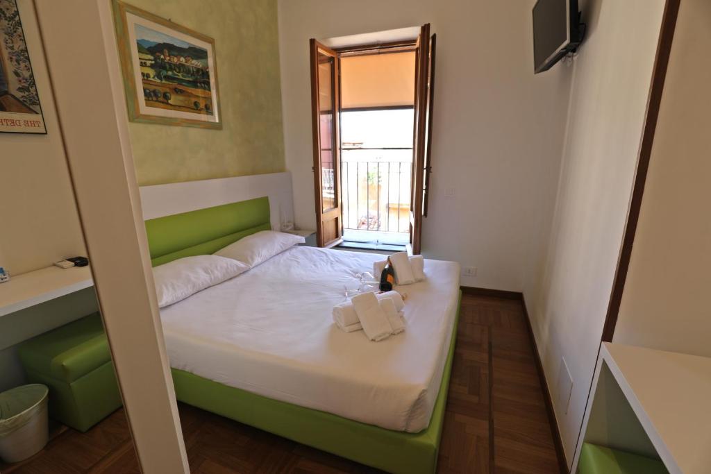 a small room with a bed and a window at Romerooms Condotti in Rome