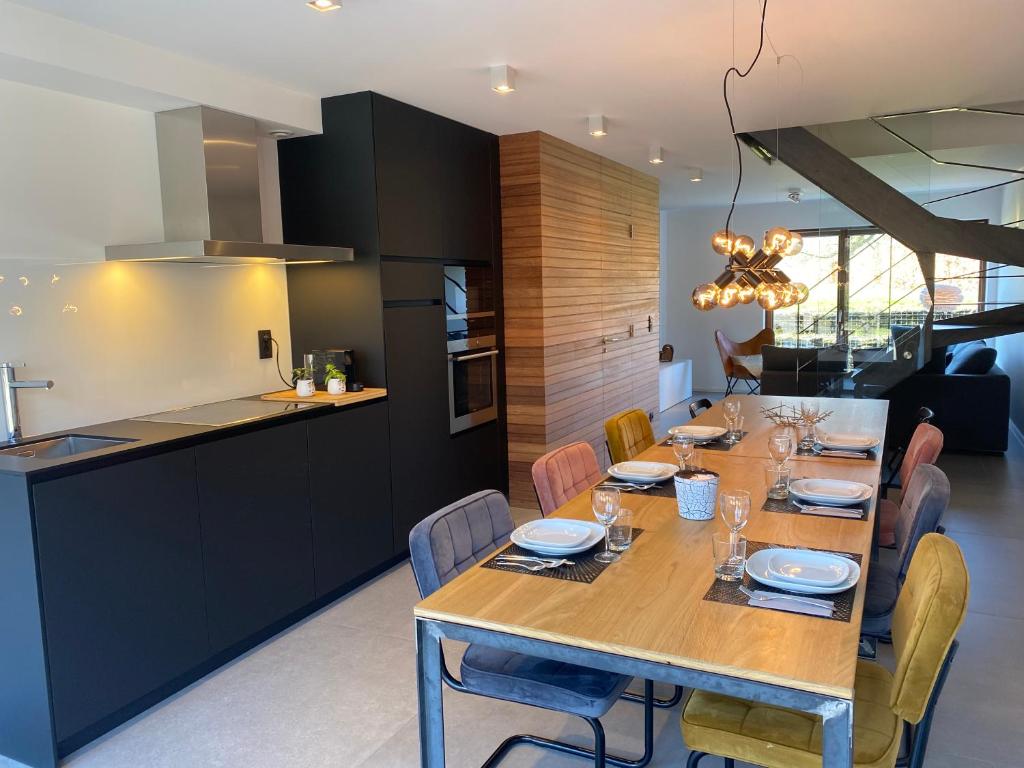 a kitchen and dining room with a wooden table and chairs at Gîte Origami in Limerlé