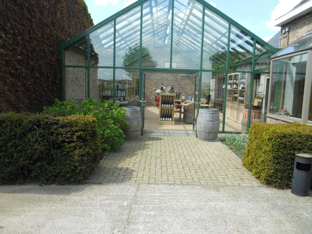 un edificio de cristal con una pasarela delante de él en Tannine et Cuisine, en Jabbeke