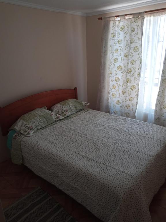 a bedroom with a bed and a window with curtains at Hospedaje Walgün in La Serena
