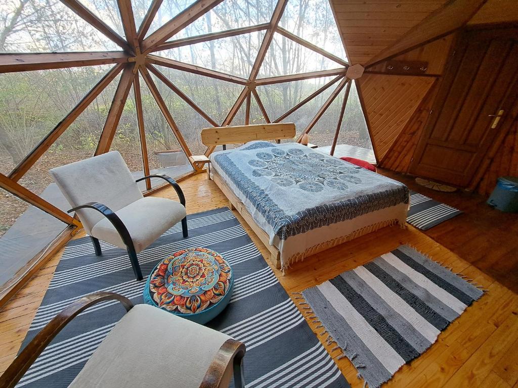 una camera con letto e sedie in tenda di Lélek Lak Dome a Debrecen