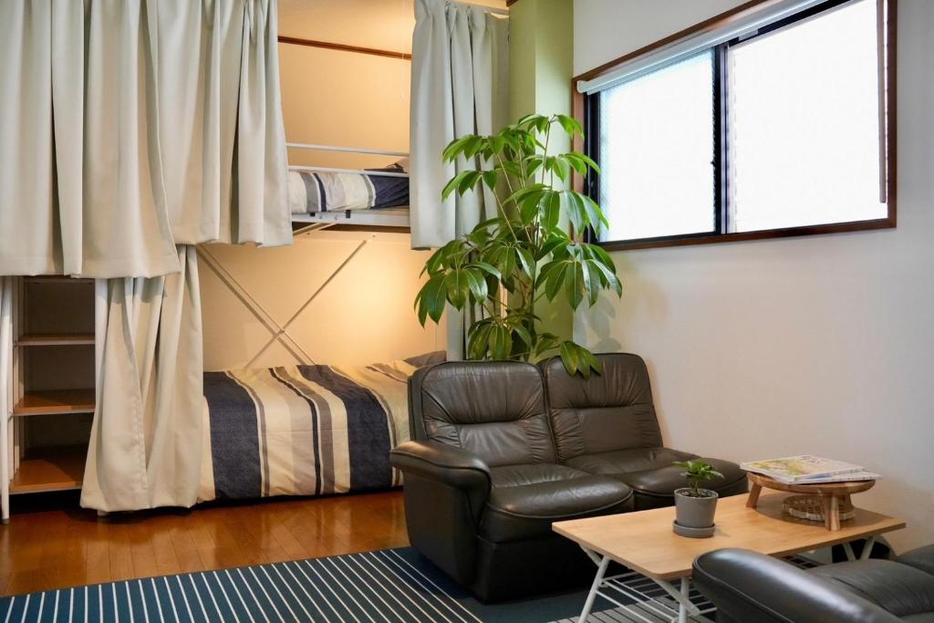 a living room with a chair and a bed at Soma guest house "mawari" - Vacation STAY 14744 in Soma