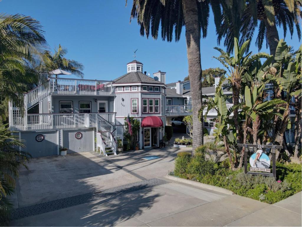 una grande casa bianca con palme di fronte di Pelican Cove Inn a Carlsbad