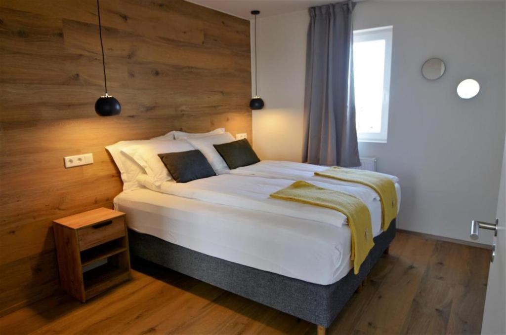 a bedroom with a large bed with a wooden wall at Stracta Apartments in Kirkjubæjarklaustur