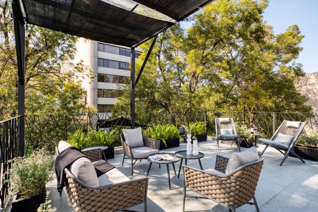 墨西哥城的住宿－ULIV Park Polanco，一个带桌椅的庭院和一座建筑