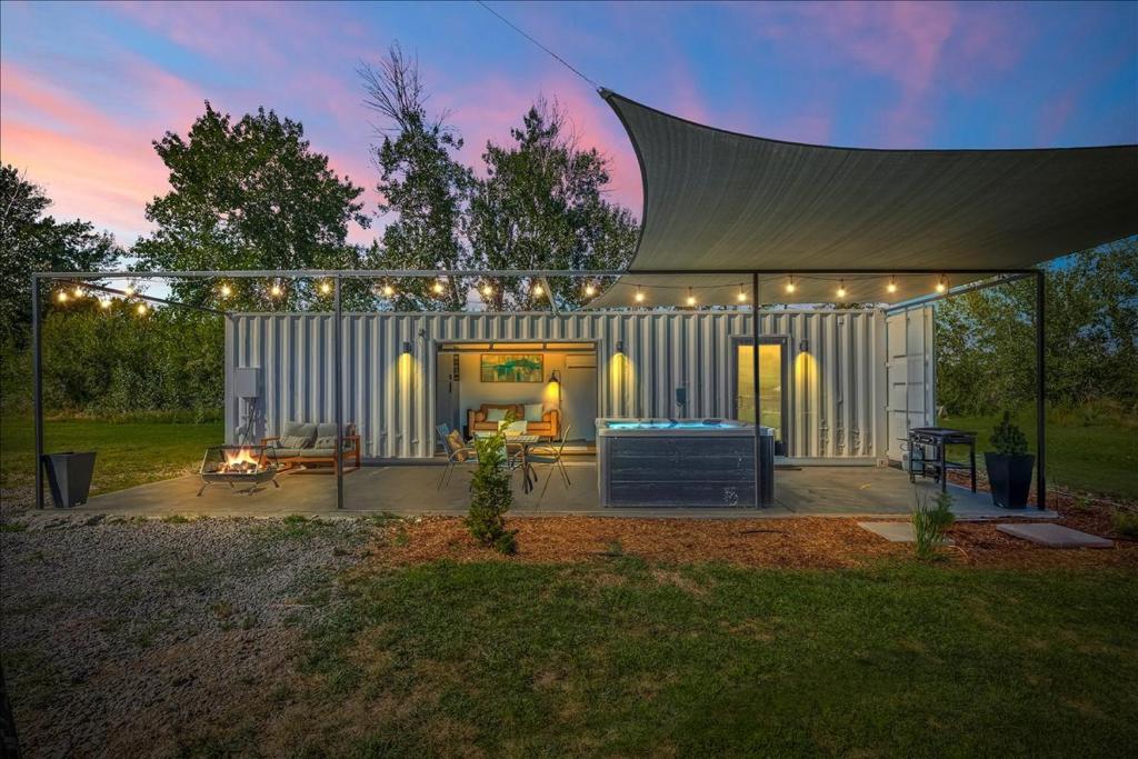 a white shed with a pergola and a patio at The River Box - Luxury Container Home - views and Hot Tub in Yakima