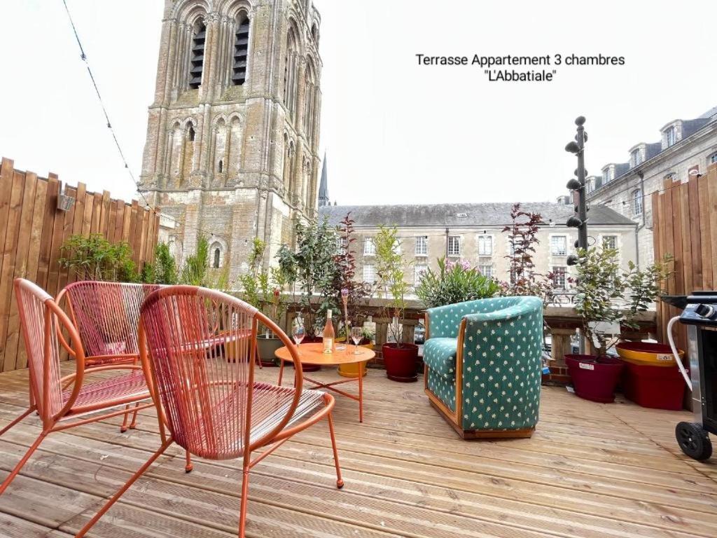 une terrasse avec des chaises, une table et une église dans l'établissement Cœur de Vendôme, à Vendôme