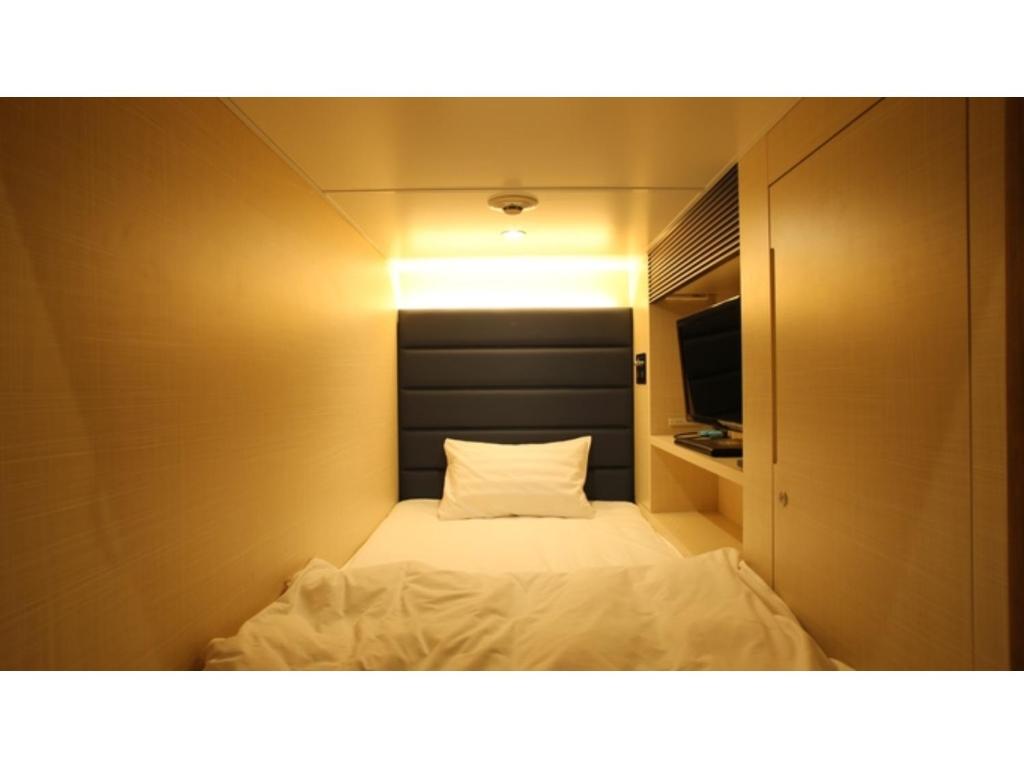 a small room with a bed and a tv at Green Rich Hotel Naha - Vacation STAY 59243v in Naha
