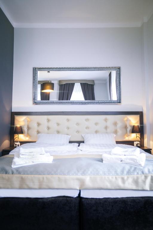a bedroom with a large white bed with a mirror at Villa Elizabeth in Bolków