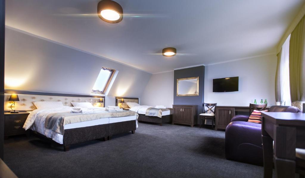 una habitación de hotel con dos camas y un sofá en Villa Elizabeth, en Bolków