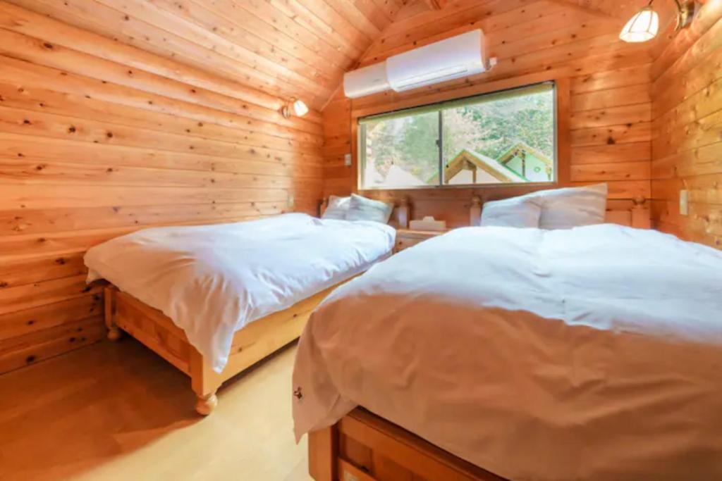 sypialnia z 2 łóżkami w drewnianym domku w obiekcie Mori no Kuni - Vacation STAY 03993v w mieście Ōma