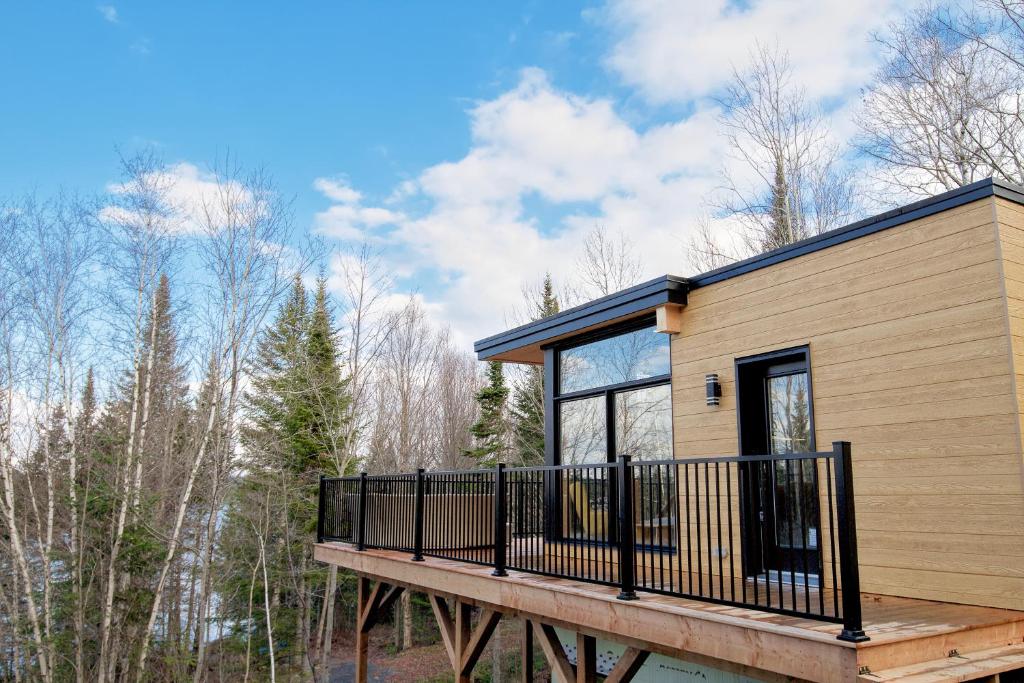 a modular home with a deck and trees at Elk in Audet