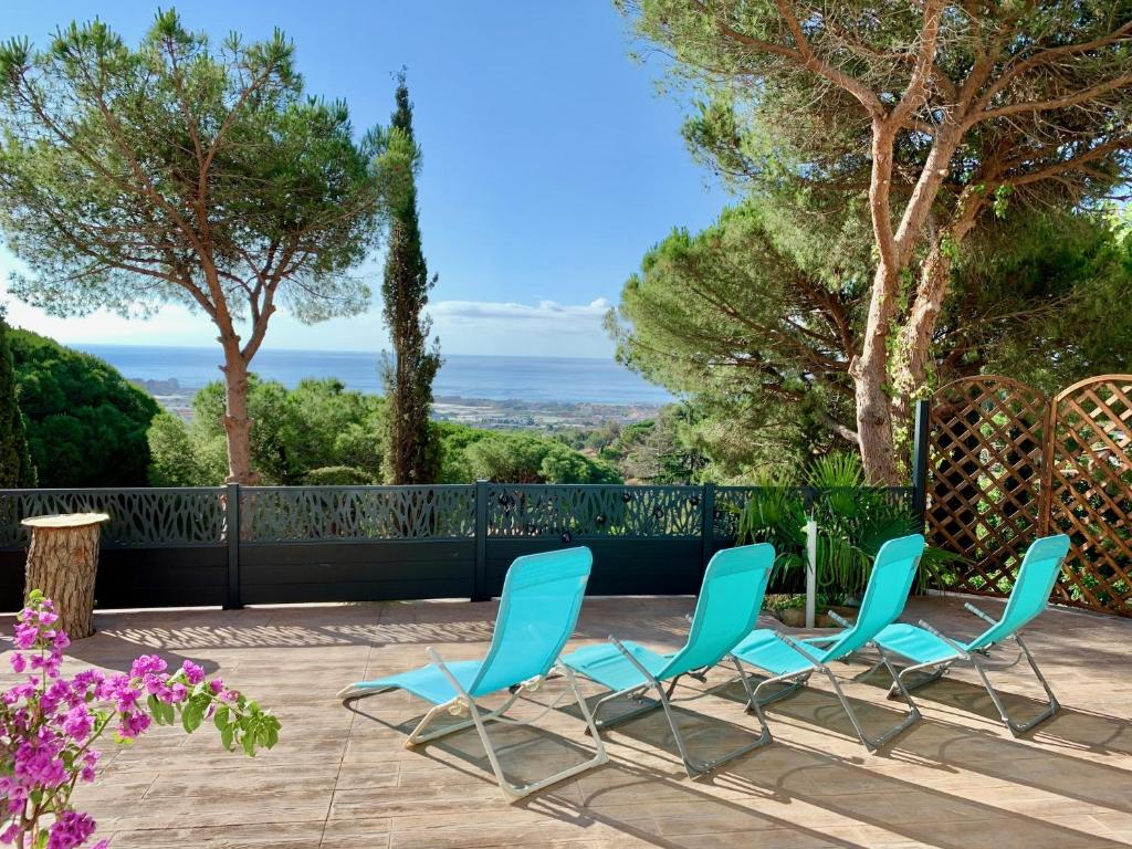 2 blaue Stühle und ein Tisch auf einer Terrasse in der Unterkunft Les Terrasses de la Cisa, 20kms de BCN in Premia de Dalt