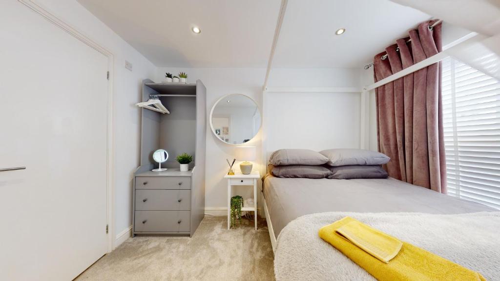 een witte slaapkamer met een bed en een raam bij Modern Cardiff City Apartment in Cardiff